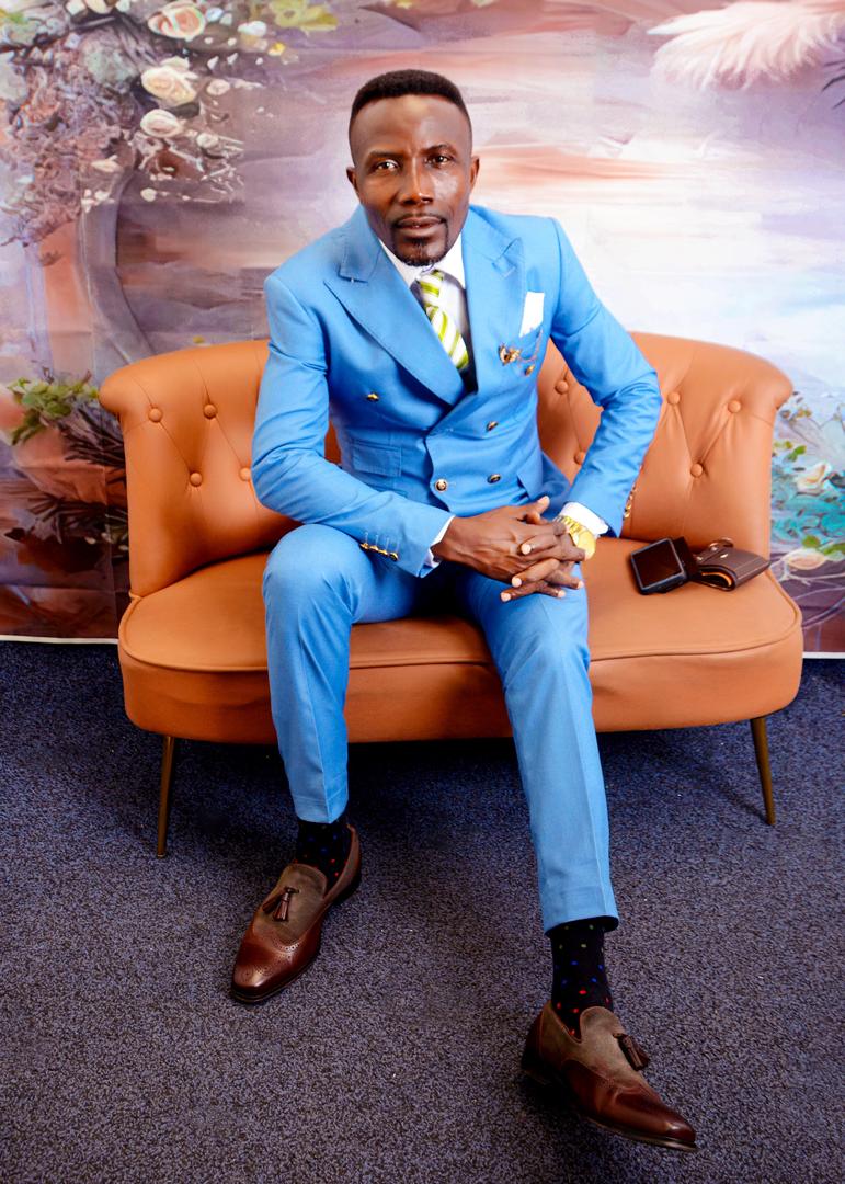 Apostle Isaac Adjei seated in a blue suit