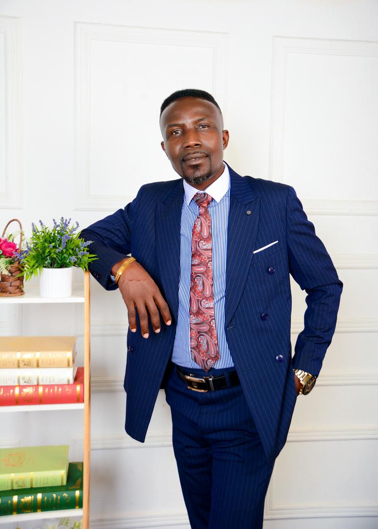 Apostle Isaac Adjei standing in a navy suit